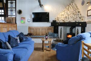 a living room with two blue couches and a fireplace at 3 Bed in Llanfairpwllgwyngyll oc-wai194 in Dwyran