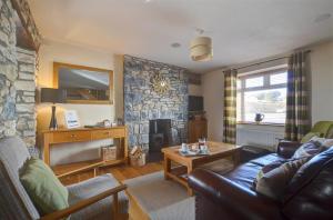a living room with a couch and a stone wall at 3 Bed in Southerndown oc-way216 in Southerndown