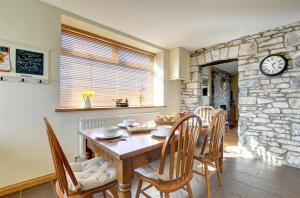 a dining room with a table and a stone wall at 3 Bed in Southerndown oc-way216 in Southerndown