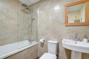 a bathroom with a toilet and a sink and a shower at 3 Bed in Southerndown oc-way216 in Southerndown +11 photos