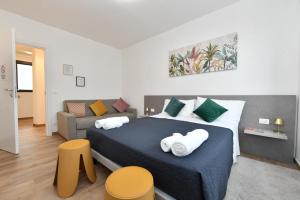 a bedroom with a large bed and a couch at Mondeo B&B in Udine