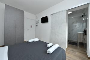 a bedroom with a bed with two white towels on it at Mondeo B&B in Udine