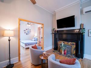 a living room with a fireplace with a television above it at Oak and Ember at Marietta Square in Marietta