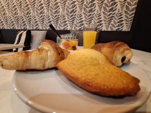 a plate of food with bread and a glass of orange juice at Hotel de Jouvence in Dax
