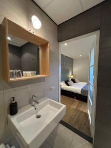 a bathroom with a sink and a bedroom with a bed at Hoeve Montigny B&B in Giethoorn +63 photos