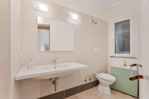 a white bathroom with a sink and a toilet at Sea Whisper Volastra in Volastra +13 photos