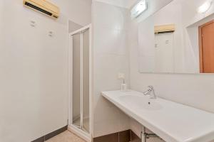 a white bathroom with a sink and a mirror at Sea Whisper Volastra in Volastra