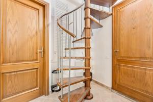 a wooden spiral staircase in a hallway next to a door at Sea Whisper Volastra in Volastra