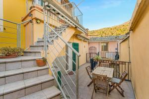 a balcony with a table and chairs and stairs at Sea Whisper Volastra in Volastra