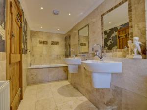 a bathroom with two sinks and a tub at 4 Bed in Llandudno Junction oc-58301 in Llandudno Junction +17 photos