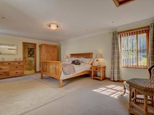 a bedroom with a bed and a table and a window at 4 Bed in Llandudno Junction oc-58301 in Llandudno Junction