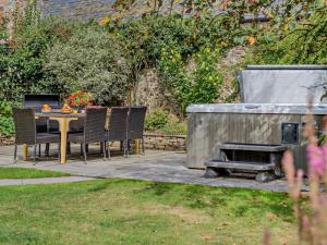 a patio with a table and chairs and a grill at 4 Bed in Bude oc-ssham in Stratton