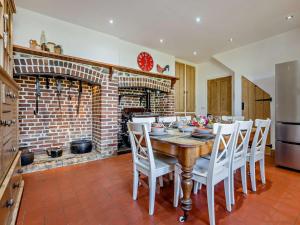 a kitchen with a wooden table and a brick fireplace at 4 Bed in Bude oc-ssham in Stratton