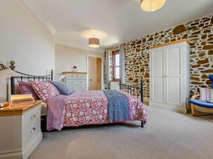 a bedroom with a bed and a stone wall at 4 Bed in Bude oc-ssham in Stratton