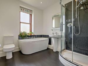 a bathroom with a tub and a toilet and a shower at 4 Bed in Bude oc-ssham in Stratton +22 photos
