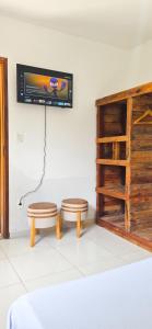 a room with two stools and a tv on the wall at Aloogar Caragua Beach in Caraguatatuba +44 photos