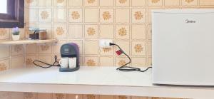 a kitchen counter with a phone plugged into an outlet at Aloogar Caragua Beach in Caraguatatuba