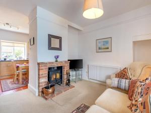 a living room with a fireplace and a couch at 2 Bed in Holt oc-ncc66 in Blakeney