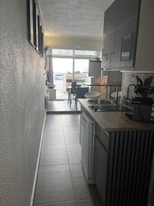 a kitchen with white cabinets and a tile floor at Sunset in Cap d'Agde