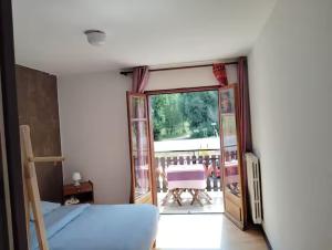 a bedroom with a bed and a door to a patio at Chambre La Charolaise in Aubessagne