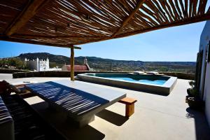a patio with a swimming pool and a table at Sunwave Mykonos Villa in Mykonos