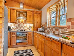 a kitchen with wooden cabinets and a stove top oven at 3 Bed in Dunsyre oc-lk15m in Walston +11 photos