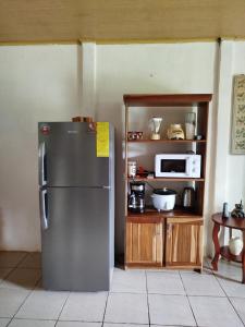 a kitchen with a stainless steel refrigerator and a microwave at Paraíso Verde in Siquirres +21 photos