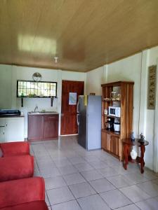 a kitchen with a red couch and a refrigerator at Paraíso Verde in Siquirres