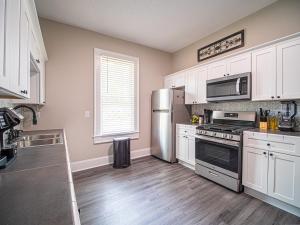 a kitchen with white cabinets and a stainless steel refrigerator at Marietta Square's Home Away! in Marietta
