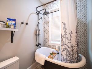 a bathroom with a tub and a shower curtain at Marietta Square's Home Away! in Marietta +16 photos