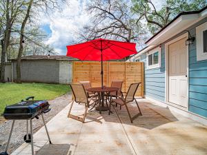 a table and chairs with a red umbrella and a grill at Marietta Square's Home Away! in Marietta