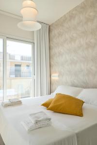 a bedroom with a white bed with a large window at Room45 in Marzamemi