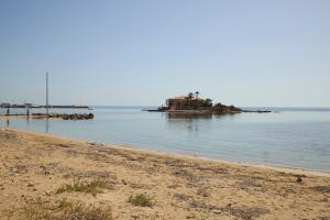 a beach with a house in the middle of the water at Room45 in Marzamemi