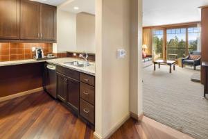 a kitchen with a sink and a living room at 5058 - Grand Suncadia Mountain Lodge with Hot Tub and Views in Cle Elum
