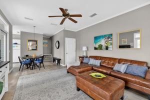 a living room with a couch and a ceiling fan at 221 Olive Way in Saint Simons Island