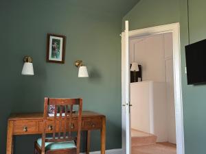 a room with a desk and a chair and a mirror at Dunan Hotel in Breasclete