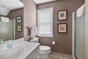 a bathroom with a sink toilet and a window at 221 Olive Way in Saint Simons Island +12 photos