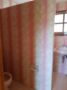a bathroom with a toilet and a sink at Very cute and spacious complete house with a fireplace! in Teziutlán