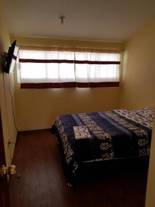 a bedroom with a bed in front of a window at Very cute and spacious complete house with a fireplace! in Teziutlán