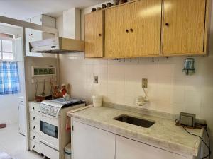 a kitchen with a sink and a stove at Apartamento com piscina em Olaria in Nova Friburgo