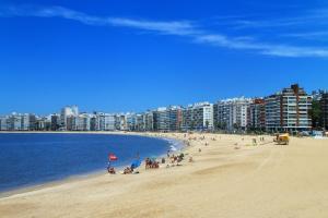 a group of people on a beach near the water at Luxury Family 3 Suites Oceanfront Buceo in Montevideo