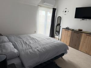 a bedroom with a bed and a flat screen tv at Apartmani Preradović in Pančevo