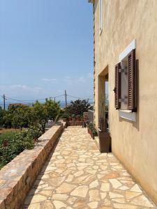 a stone walkway next to a building with a window at Olea House in Elia Laconias