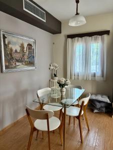 a dining room with a glass table and chairs at Olea House in Elia Laconias