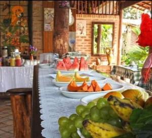 a long table with plates of fruit on it at MATURI CENTRO in Pipa