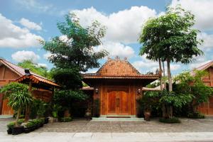 a house with a wooden door in a courtyard at Joglo Mandapa Boutique Hotel in Yogyakarta