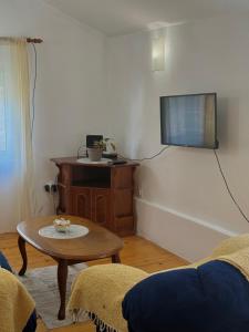 a living room with a table and a flat screen tv at Radovic Apartmani in Herceg-Novi