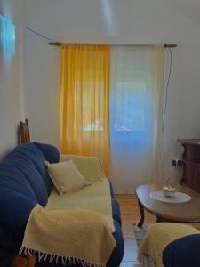 a living room with a blue couch and a table at Radovic Apartmani in Herceg-Novi