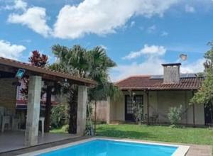 a house with a swimming pool in front of a house at Casa Compartilhada na CBF, granja comary in Teresópolis