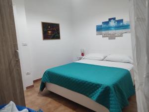 a white bedroom with a bed with a green blanket at Tropea's green terrace in Tropea +13 photos